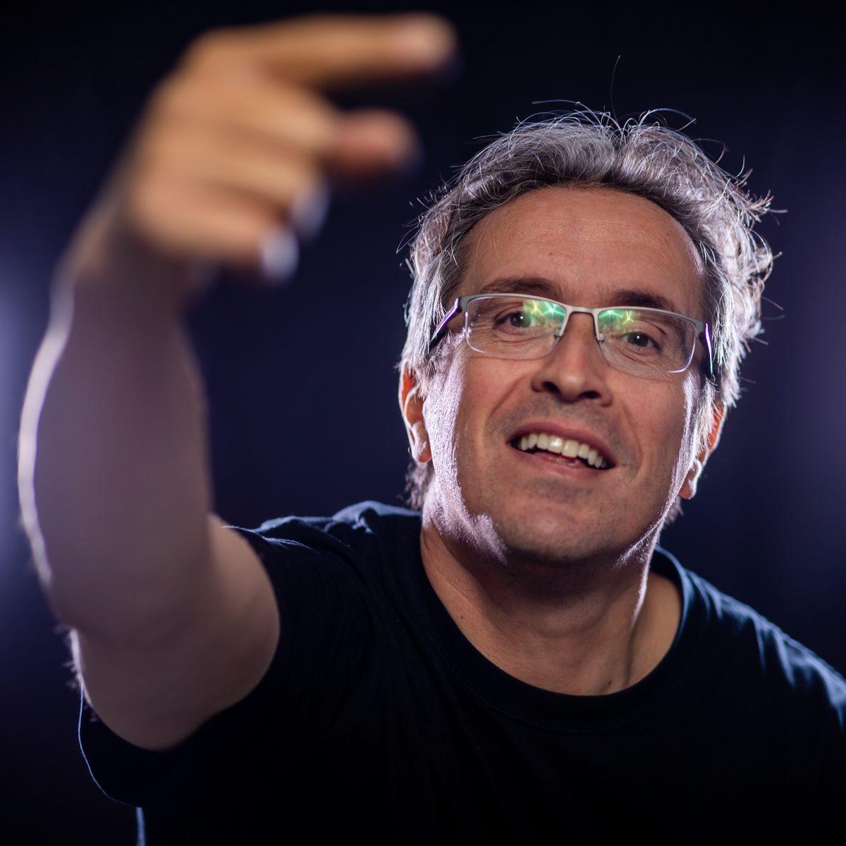 Felice Marra sul palco, braccio teso verso il pubblico, luce blu.
